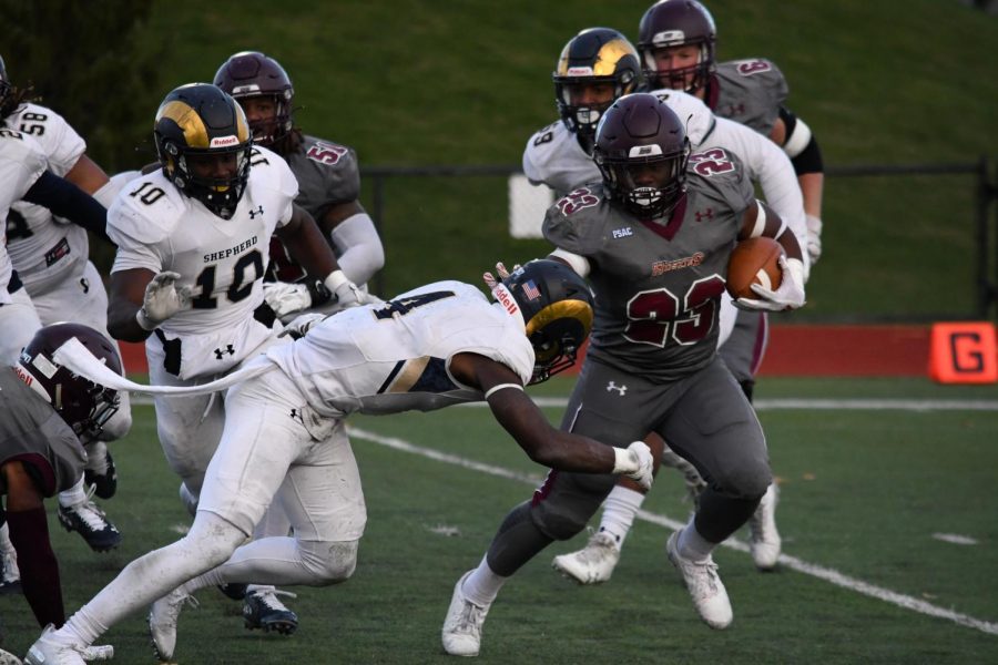 Running back Khalil Nelson (top) is seen stiff arming a Shepperd University Ram during this past Saturday’s contest. Nelson had 44 yards rushing on the ground and added 19 yards through the air with his longest reception of the year. No. 23 is on pace to eclipse 600 yards rushing during his banner year on the offensive side of the ball.     