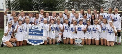 The Womens soccer team celebrates their PSAC Championship win on the field.