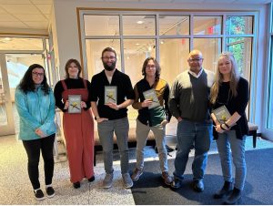 From left to right: Sydney Kyle, Jacklyn Price, William Clickard, Gage Dabulis, Jerry Wemple, and Sue O’Donnell at the Warren Launch Party holding the 2023 edition. Photo by Lenna Kidd.