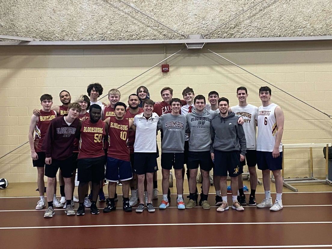 Men's Volleyball Poses For A Picture. Photo via Alex Bartman. 