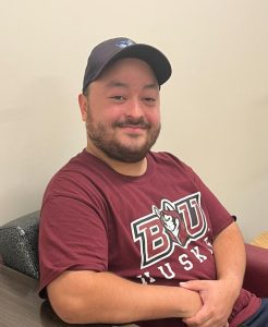 Nodir smiling in the Husky Lounge. 