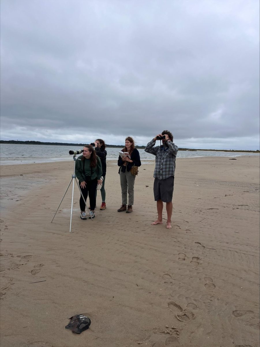 Dr. Clay Corbin (right) with students at Assateague National Seashore, observing birds through lenses.