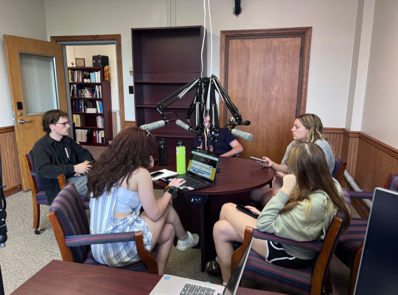 Nicholas Thompson, Maddy Mamourian, Becca Sokolowski, Isabella Salvatore, and Caleb Brown sit at their microphones in the temporary Waller radio station. 