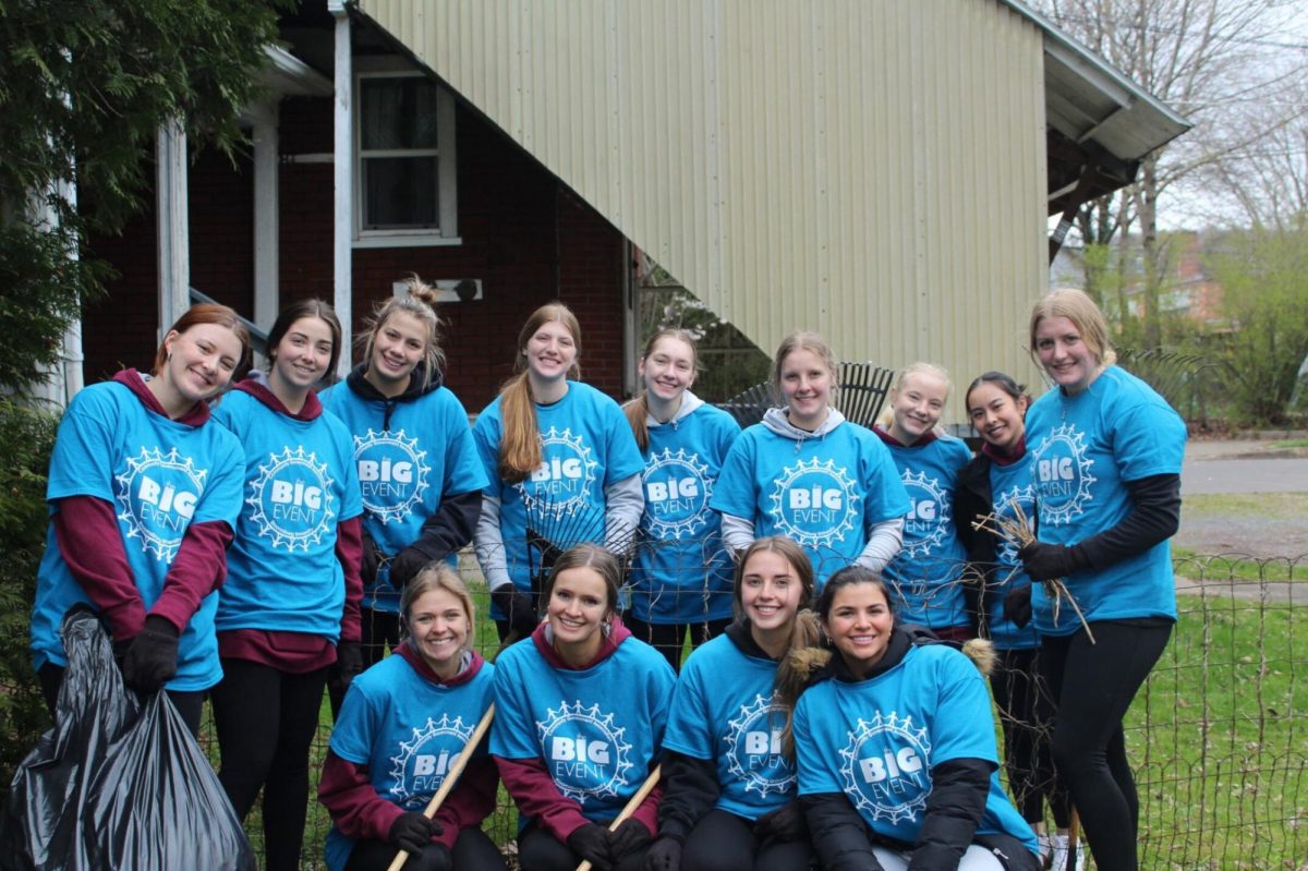 Women's Volleyball pictured during a quick break while cleaning up a walk way and the back yard of a resident. 