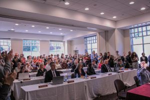 Students and faculty applauding Dr. Hawrelak for the speech given at the Council of Trustees (CoT). Pictured in the bottom right is President Bashar Hanna.