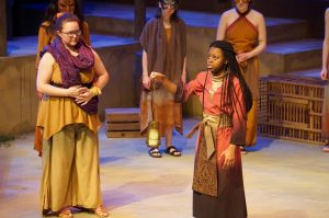 Cassandra (Xaria “Mickey” Brathwaite) holds a flame, representing her gift of prophecy.