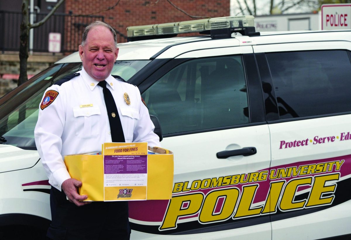 Leo Sokosloski holding a "food for fines" box.